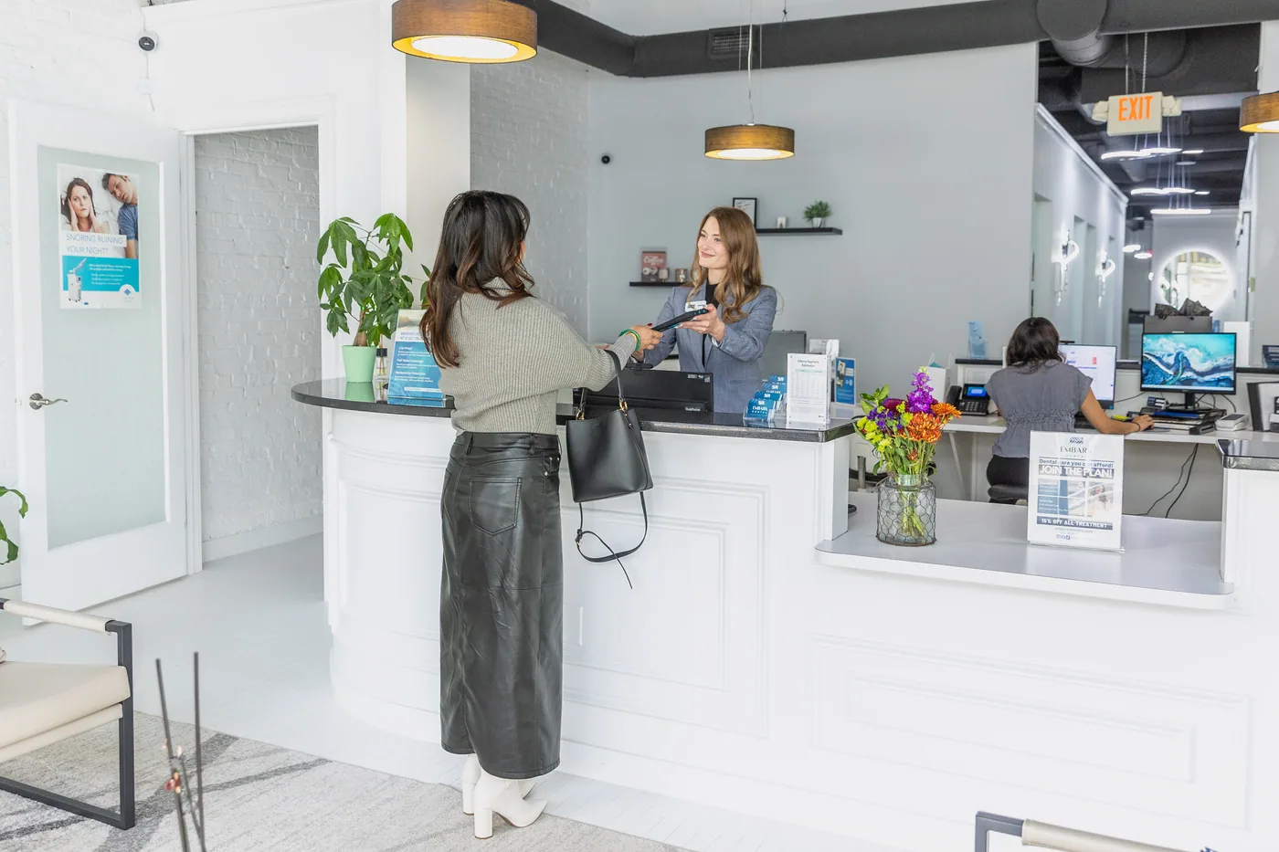 A patient checking in at the bright Embark Dental reception desk