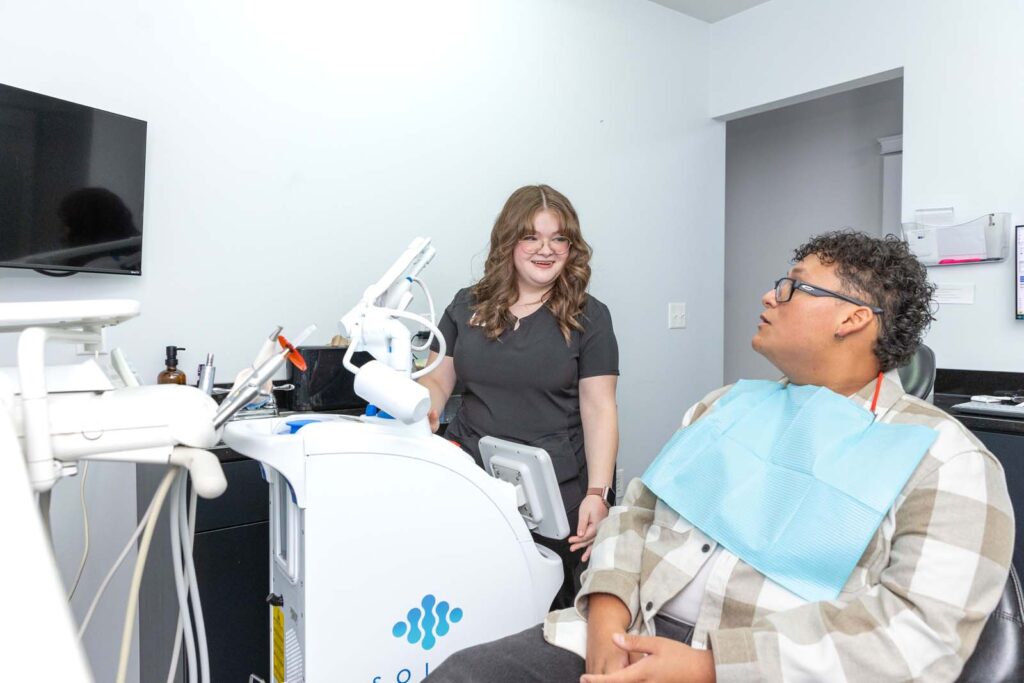 a dental hygienist visiting with a patient