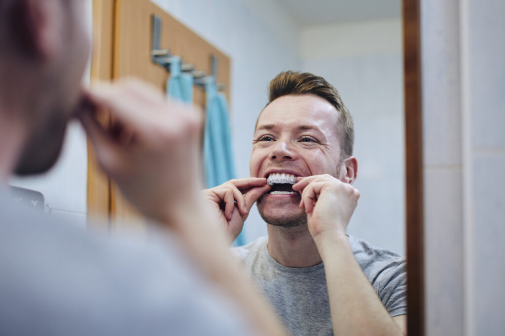 man preparing silicon tray for teeth whitening